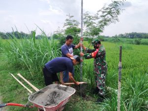 Bantu Warga, Babinsa Peleman Pasang Penerangan Lampu Jalan