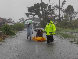 Gunakan Perahu Karet, Polisi Di Kota Pekalongan Sisir Banjir Evakuasi Warga Terisolir Dan Bagikan Masker
