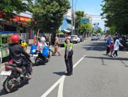 Sigap Bantu Warga Menyeberang di Tengah Padatnya Arus Lalin Kota Pekalongan